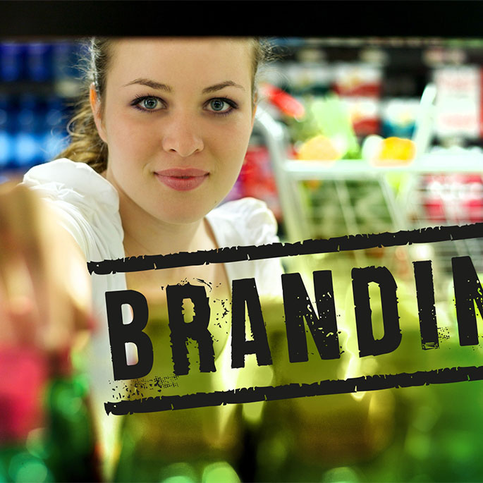 Frau greift in Einkaufsregal. Im Vordergrund Aufschrift BRANDING.