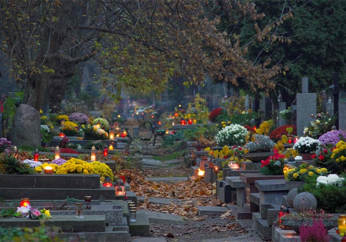 Bewaldeter Friedhof mit Grablichtern