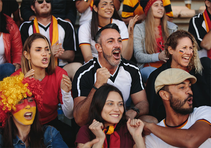 Deutsche Fussballfans freudestrahlend beim Schauen eines Spieles.