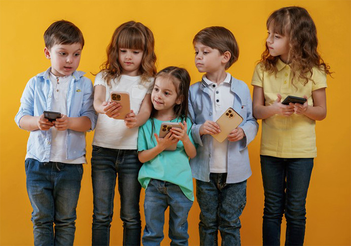 Junge Kinder mit Handys machen ein Selfie.