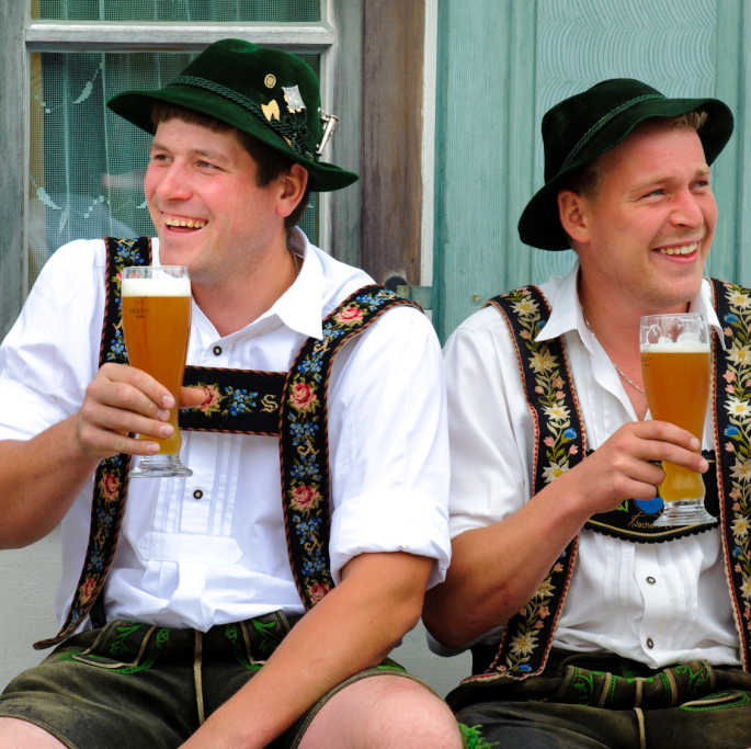 Bayerische Männer in Tracht mit Weizenbier
